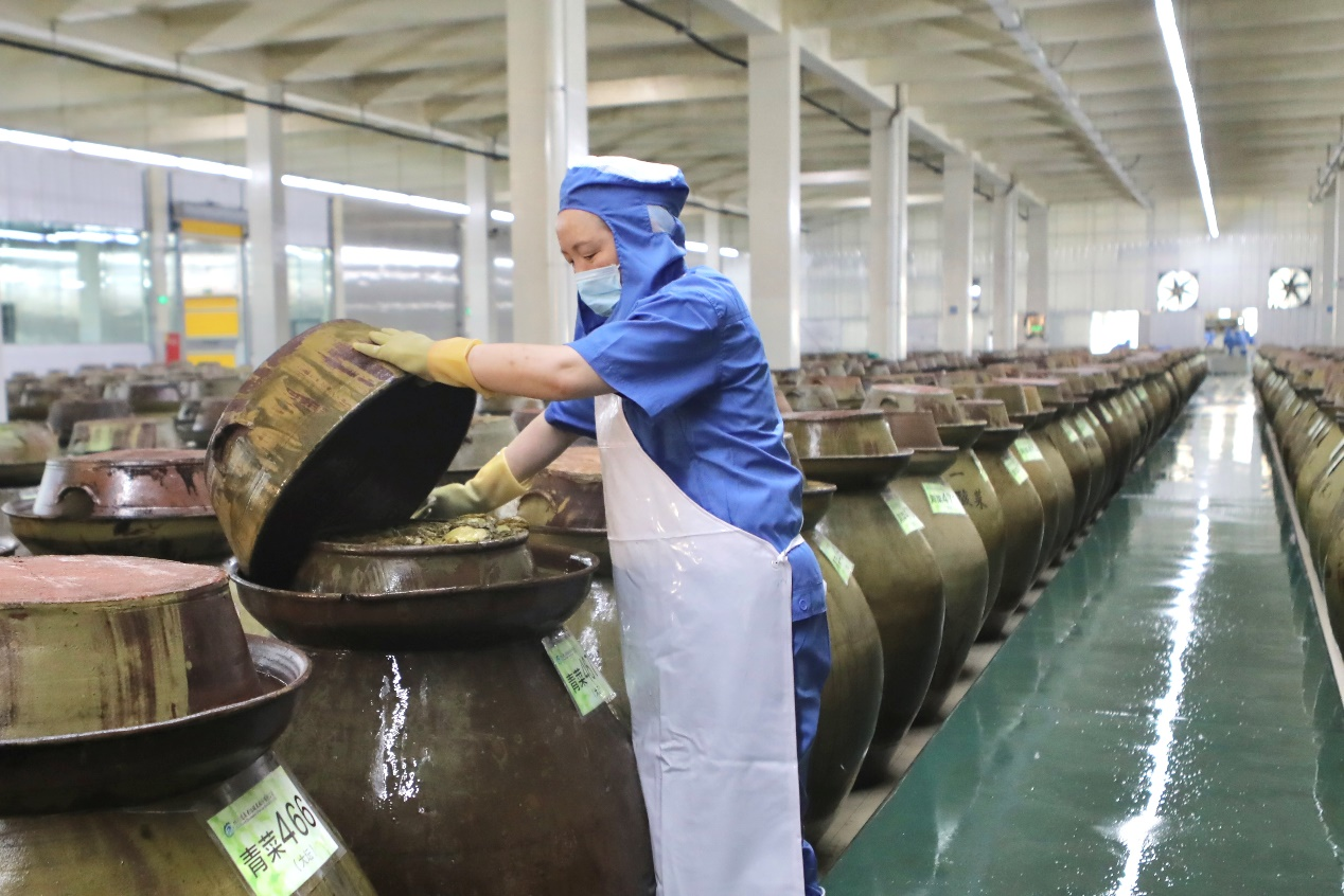 Workers work in the secondary fermentation area.